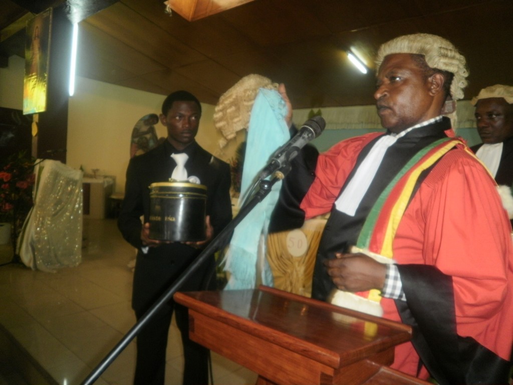 Justice Alfred Suh hands over the wig of late Justice Mwambo to his nephew, Lucas Nyoki