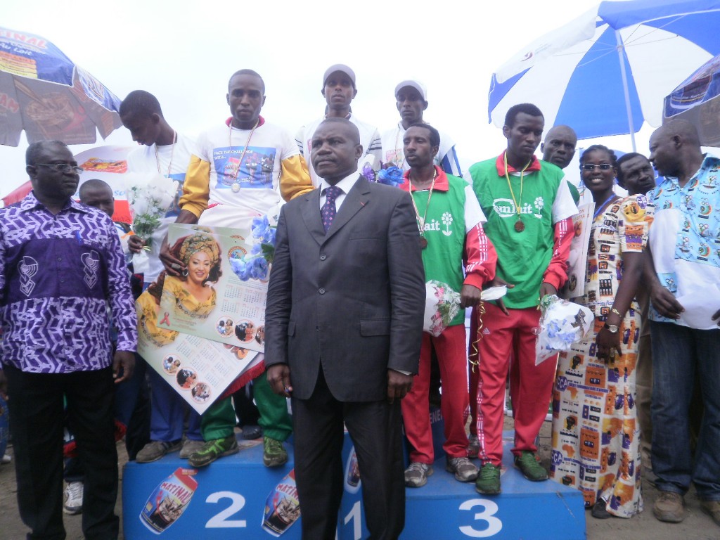 Athletics Federation President Jacques Sebastien Mbous in suit-pose with members of the second relay team