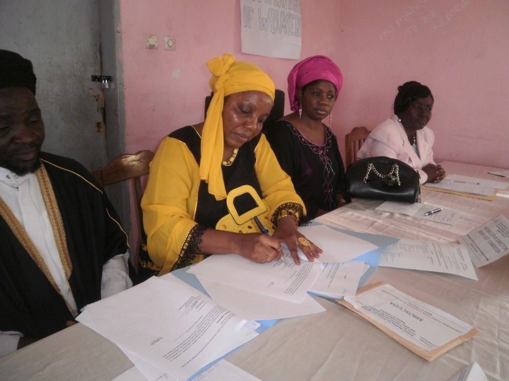 Esther Omam Executive Director of Reach Out signs the contract for development with Mbororo Muslim women in Buea.