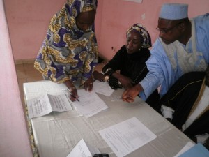 Representative of Mbororo women signing out their financial assistance from Reach Out