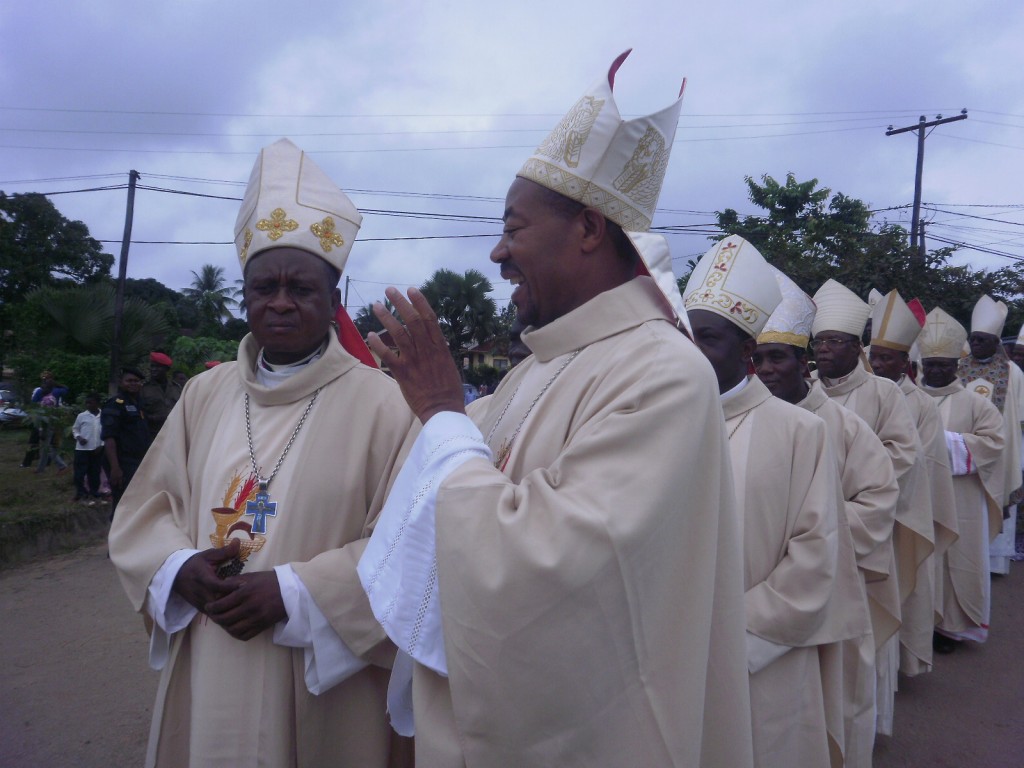 Mgr. Befe (L) Mgr Bayemi share light moments during the procession